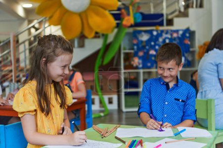 Photo for Cute girl and boy sit and draw together in preschool institution. High quality photo - Royalty Free Image