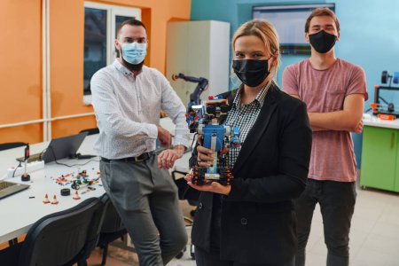 Photo for A group of colleagues working together in a robotics laboratory, focusing on the intricate fields of robotics and 3D printing. Showcase their dedication to innovation, as they engage in research - Royalty Free Image