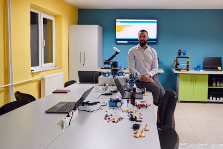 Foto de Un hombre barbudo en un moderno laboratorio de robótica, inmerso en la investigación y rodeado de tecnología y equipos avanzados - Imagen libre de derechos