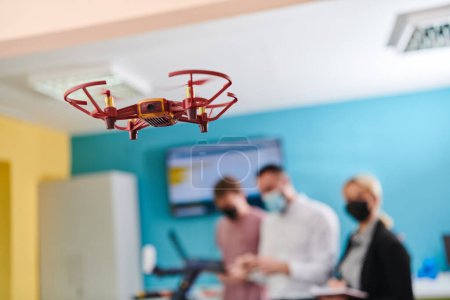 Téléchargez les photos : Un groupe d'étudiants travaillant ensemble dans un laboratoire, dédié à l'exploration des capacités aérodynamiques d'un drone. - en image libre de droit