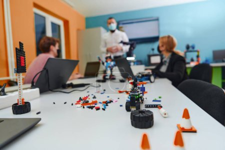 Photo for A group of colleagues working together in a robotics laboratory, focusing on the intricate fields of robotics and 3D printing. Showcase their dedication to innovation, as they engage in research - Royalty Free Image