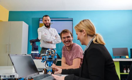 Téléchargez les photos : Un groupe de collègues travaillant ensemble dans un laboratoire de robotique, se concentrant sur les domaines complexes de la robotique et de l'impression 3D. Démontrer leur dévouement à l'innovation, alors qu'ils s'engagent dans la recherche - en image libre de droit