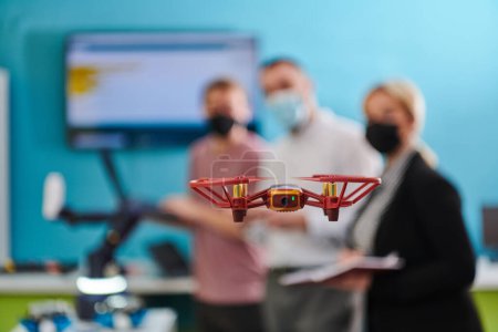 Téléchargez les photos : Un groupe d'étudiants travaillant ensemble dans un laboratoire, dédié à l'exploration des capacités aérodynamiques d'un drone. - en image libre de droit