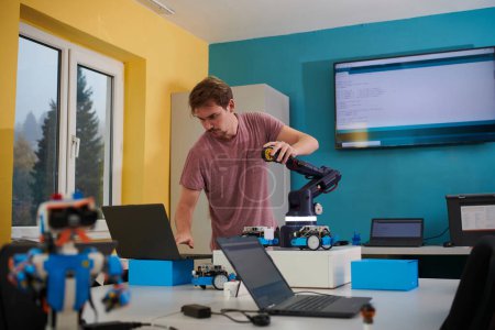 Foto de Un estudiante probando su nueva invención de un brazo robótico en el laboratorio, mostrando la culminación de su investigación y destreza tecnológica - Imagen libre de derechos