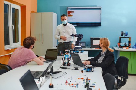 Foto de Un grupo de colegas que trabajan juntos en un laboratorio de robótica, centrándose en los intrincados campos de la robótica y la impresión 3D. Mostrar su dedicación a la innovación, mientras se dedican a la investigación - Imagen libre de derechos