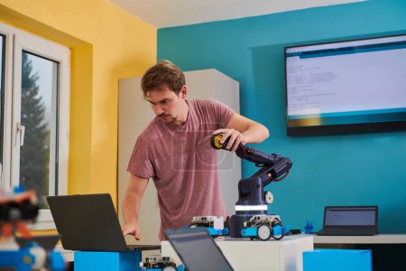 Photo for A student testing his new invention of a robotic arm in the laboratory, showcasing the culmination of his research and technological prowess - Royalty Free Image