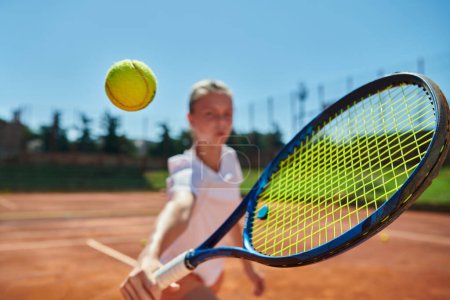 Téléchargez les photos : Photo rapprochée d'une jeune fille montrant des compétences professionnelles de tennis dans un match de compétition par une journée ensoleillée, entourée par l'esthétique moderne d'un court de tennis - en image libre de droit