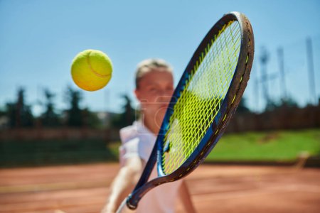 Foto de Foto de cerca de una joven que muestra habilidades profesionales de tenis en un partido competitivo en un día soleado, rodeado por la estética moderna de una cancha de tenis - Imagen libre de derechos