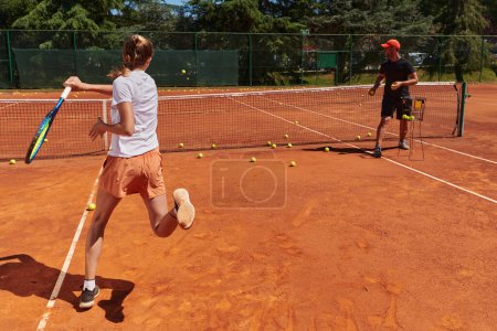 Photo for A professional tennis player and her coach training on a sunny day at the tennis court. Training and preparation of a professional tennis player. - Royalty Free Image