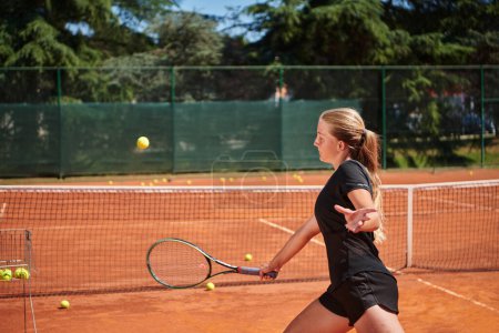 Foto de Una joven que muestra habilidades profesionales de tenis en un partido competitivo en un día soleado, rodeada por la estética moderna de una cancha de tenis - Imagen libre de derechos