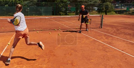 Foto de Una tenista profesional y su entrenador entrenando en un día soleado en la cancha de tenis. Formación y preparación de un tenista profesional. - Imagen libre de derechos