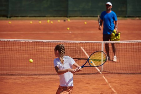 Foto de Una tenista profesional y su entrenador entrenando en un día soleado en la cancha de tenis. Formación y preparación de un tenista profesional. - Imagen libre de derechos