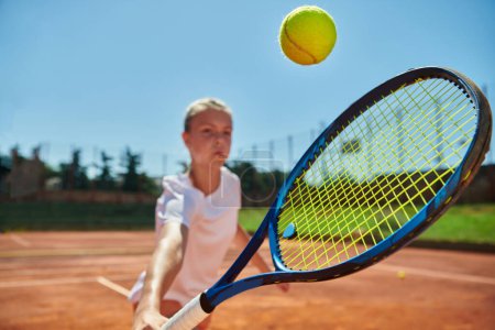 Foto de Foto de cerca de una joven que muestra habilidades profesionales de tenis en un partido competitivo en un día soleado, rodeado por la estética moderna de una cancha de tenis - Imagen libre de derechos
