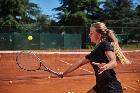 Téléchargez les photos : Une jeune fille montrant des compétences professionnelles de tennis dans un match de compétition par une journée ensoleillée, entouré par l'esthétique moderne d'un court de tennis - en image libre de droit