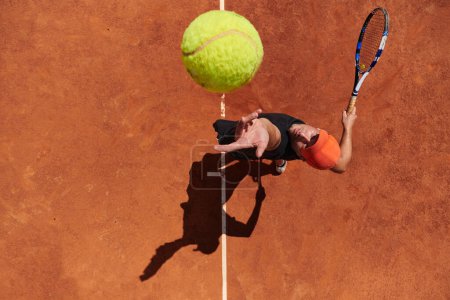 Photo for Top view of a professional tennis player serves the tennis ball on the court with precision and power. - Royalty Free Image