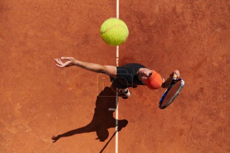 Téléchargez les photos : Vue de dessus d'un joueur de tennis professionnel sert la balle de tennis sur le terrain avec précision et puissance. - en image libre de droit
