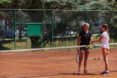 Téléchargez les photos : Joueurs de tennis debout ensemble sur le court de tennis, prêts et concentrés, se préparant pour le début de leur match. - en image libre de droit