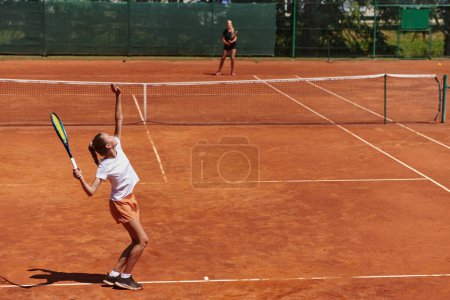 Téléchargez les photos : Jeunes filles dans un match de tennis animé par une journée ensoleillée, démontrant leurs compétences et leur enthousiasme sur un court de tennis moderne - en image libre de droit