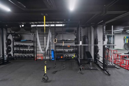 Un gymnase moderne vide avec une variété d'équipements, offrant un espace d'entraînement spacieux, fonctionnel et bien équipé pour les entraînements, fitness et musculation.