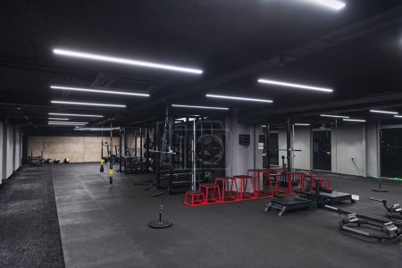 An empty modern gymnasium with a variety of equipment, offering a spacious, functional, and well-equipped training facility for workouts, fitness, and strength training.
