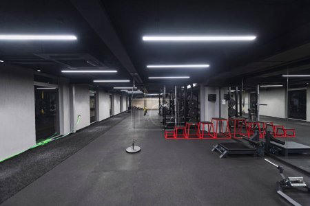 Photo for An empty modern gymnasium with a variety of equipment, offering a spacious, functional, and well-equipped training facility for workouts, fitness, and strength training. - Royalty Free Image