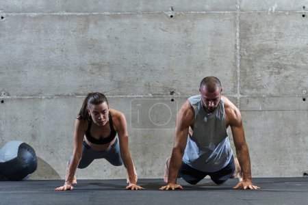 Téléchargez les photos : Un couple attrayant dans la salle de gym s'engageant dans divers exercices d'étirement ensemble, montrant leur dévouement à la forme physique, la flexibilité et le bien-être général. Avec des mouvements synchronisés, ils - en image libre de droit