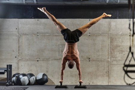 Téléchargez les photos : Un homme musclé dans une position debout, mettant en valeur son équilibre exceptionnel et le contrôle du corps tout en effectuant une variété d'exercices pour améliorer sa stabilité globale du corps et la force dans une salle de gym moderne. - en image libre de droit