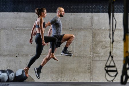 Photo for A fit couple exercising various types of jumps in a modern gym, demonstrating their physical fitness, strength, and athletic performance. - Royalty Free Image