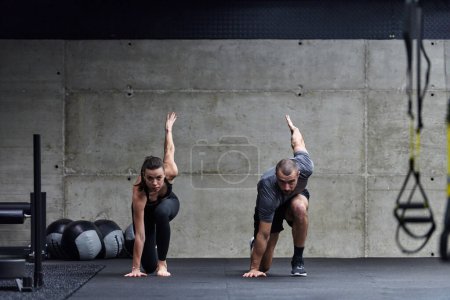 Photo for A fit couple in a modern gym, engaging in running exercises and showcasing their athletic prowess with a dynamic start - Royalty Free Image