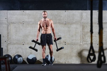 Téléchargez les photos : Un homme musclé effectue des exercices d'épaule dans une salle de gym moderne, montrant sa force et son dévouement à la forme physique - en image libre de droit