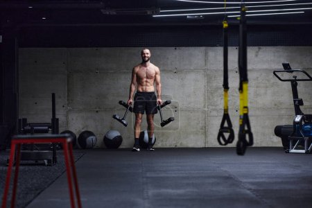 Foto de Un hombre musculoso realiza ejercicios de hombro en un gimnasio moderno, mostrando su fuerza y dedicación al fitness - Imagen libre de derechos
