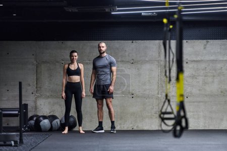 Téléchargez les photos : Homme musclé et femme en forme dans une conversation avant de commencer leur séance d'entraînement dans une salle de gym moderne - en image libre de droit