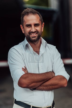 Foto de Un exitoso hombre de negocios con una camisa blanca con brazos cruzados posando al aire libre. Foto de alta calidad - Imagen libre de derechos