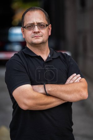 Téléchargez les photos : Un homme d'affaires à bras croisés, posant à l'extérieur. Photo de haute qualité - en image libre de droit
