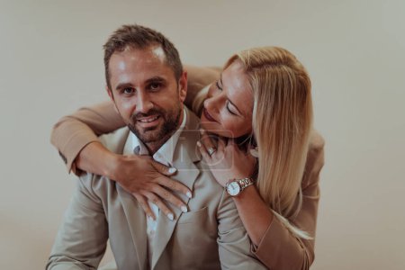Photo for A business couple poses for a photograph together against a beige backdrop, capturing their professional partnership and creating a timeless image of unity and success - Royalty Free Image