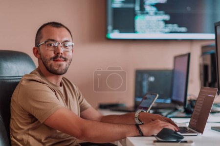 Photo for A programmer diligently testing smartphone applications while sitting in their office. High quality photo - Royalty Free Image