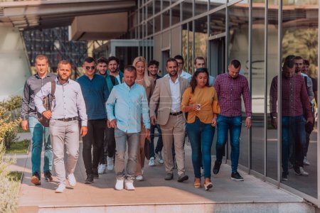 Téléchargez les photos : Un groupe diversifié d'hommes d'affaires et de collègues marchant ensemble sur leur lieu de travail, mettant en valeur la collaboration et le travail d'équipe dans l'entreprise - en image libre de droit