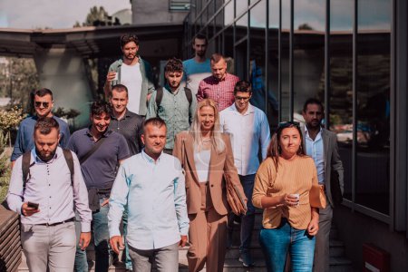 Un groupe diversifié d'hommes d'affaires et de collègues marchant ensemble sur leur lieu de travail, mettant en valeur la collaboration et le travail d'équipe dans l'entreprise