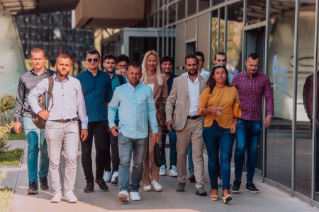 Foto de Un grupo diverso de empresarios y colegas caminando juntos por su lugar de trabajo, mostrando la colaboración y el trabajo en equipo en la empresa - Imagen libre de derechos