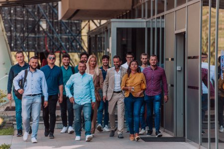 Photo for A diverse group of businessmen and colleagues walking together by their workplace, showcasing collaboration and teamwork in the company - Royalty Free Image