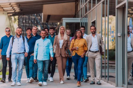 Foto de Un grupo diverso de empresarios y colegas caminando juntos por su lugar de trabajo, mostrando la colaboración y el trabajo en equipo en la empresa - Imagen libre de derechos