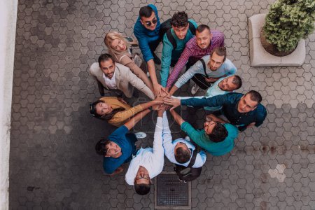 Foto de Foto vista superior de un grupo de empresarios y colegas tomados de la mano, mirando hacia la cámara, simbolizando la unidad y el trabajo en equipo - Imagen libre de derechos