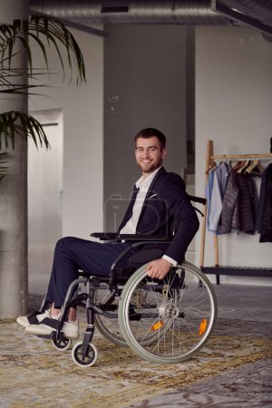 Foto de Un hombre de negocios en silla de ruedas llama la atención, simbolizando la resiliencia y el éxito en medio de un entorno de oficina moderno y dinámico - Imagen libre de derechos