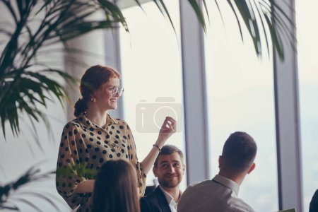 Photo for A group of young business professionals in a modern office attentively listens to colleague presentation, showcasing a dynamic and collaborative atmosphere as they exchange ideas and strive for - Royalty Free Image