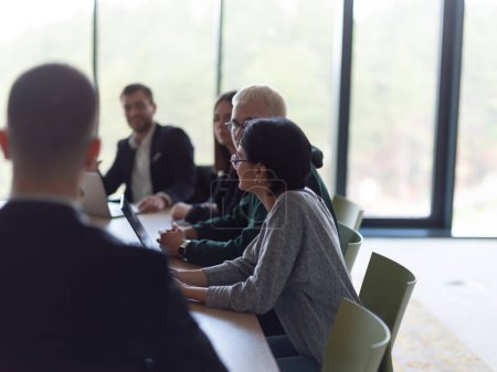 Foto de Un grupo diverso de profesionales de negocios, incluyendo una persona con discapacidad, se reunieron en una oficina moderna para una reunión productiva e inclusiva - Imagen libre de derechos