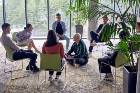 Téléchargez les photos : Un homme assis au centre d'un cercle, partageant passionnément ses idées d'affaires avec ses collègues, favorisant une atmosphère de collaboration et d'innovation dans un milieu de travail dynamique et engageant - en image libre de droit