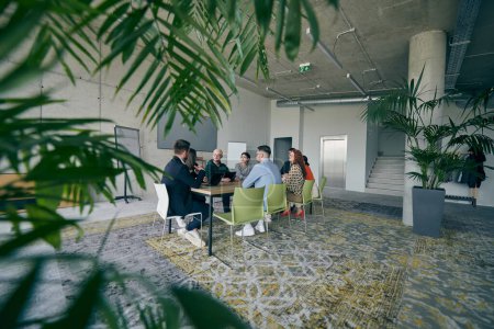 Photo for A diverse group of business professionals gathered at a modern office for a productive and inclusive meeting. - Royalty Free Image