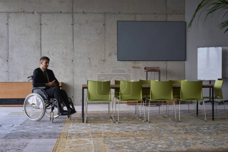 Photo for Businessman in a wheelchair in a modern office lonely after a busy day. High quality photo - Royalty Free Image