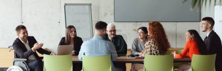 Photo for Wide crop photo of a diverse group of business professionals, including an person with a disability, gathered at a modern office for a productive and inclusive meeting - Royalty Free Image