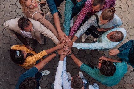 Téléchargez les photos : Photo vue du dessus d'un groupe de gens d'affaires et de collègues se tenant ensemble la main, regardant vers la caméra, symbolisant l'unité et le travail d'équipe - en image libre de droit